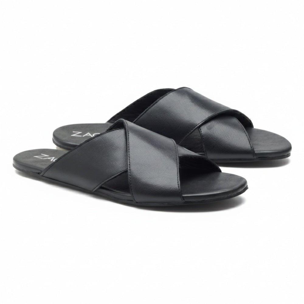 Ein Paar schwarze MANQA-Sandalen von ZAQQ aus feinem Nappaleder mit überkreuzten Riemen und flacher Sohle, elegant vor einem weißen Hintergrund präsentiert.