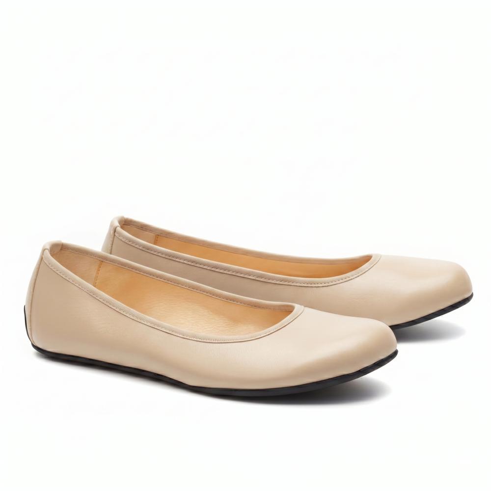 „QARMA Beige“ von ZAQQ ist ein Paar Ballerinas aus luxuriösem Nappaleder mit abgerundeter Spitze und tiefem Ausschnitt an den Seiten, elegant auf weißem Hintergrund präsentiert.