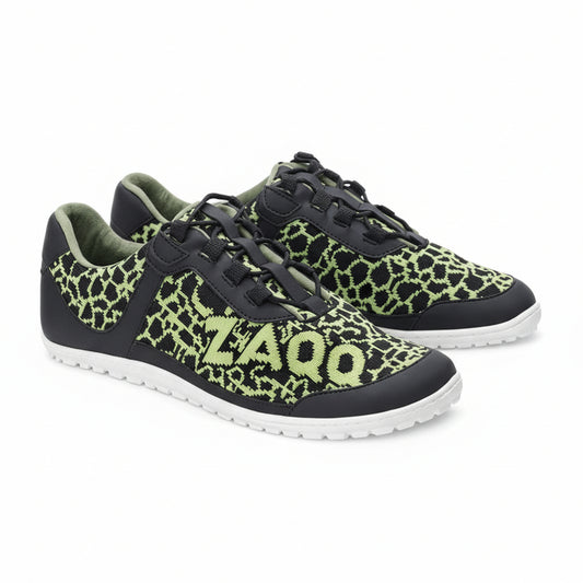 Die QINGSTON Green Sneaker von ZAQQ zeigen neongrüne geometrische Muster mit der Nummer 2400 auf der Seite, auf einem eleganten schwarzen Hintergrund. Sie verfügen über weiße Sohlen und schwarze Schnürsenkel, alle aus veganen Materialien gefertigt, und bieten ein unverwechselbares Design, das sich deutlich von einem strahlend weißen Hintergrund abhebt.