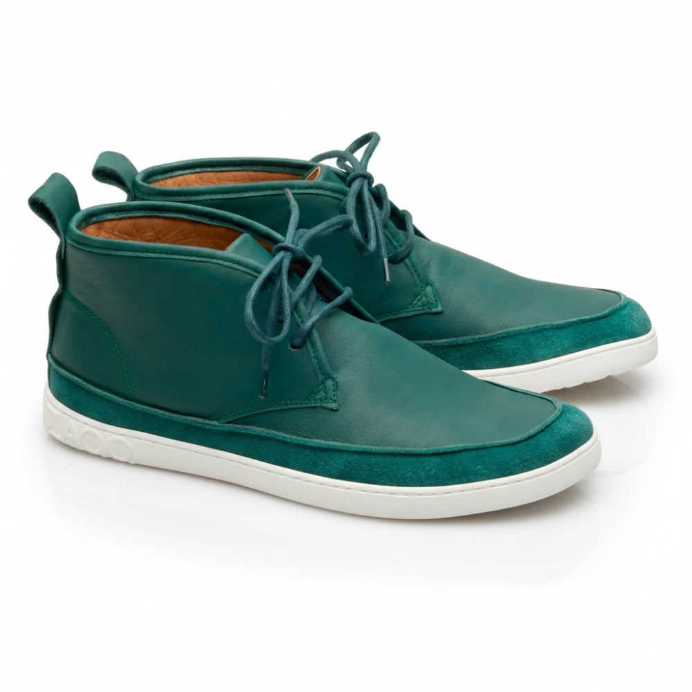 Wir präsentieren den QUITMAN Green Sneaker von ZAQQ: ein Paar stylische blaugrüne Lederschuhe mit grauen Gummisohlen und Schnürsenkeln, gefertigt aus Velours- und Glattleder. Mit einer praktischen Aufreißlasche auf der Rückseite sind sie elegant auf einem weißen Hintergrund zu sehen und zeigen sowohl die Seiten- als auch die Rückansicht.